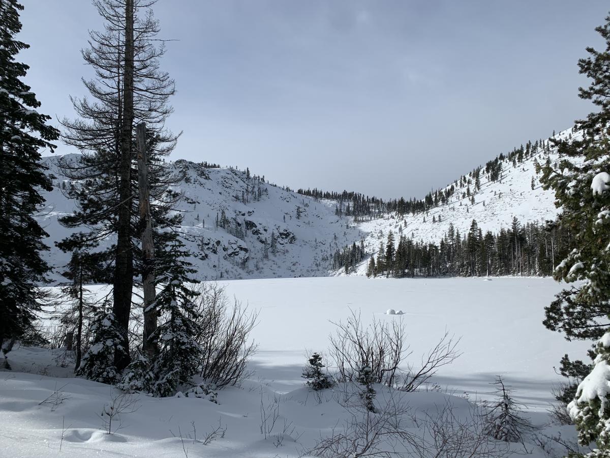 Castle Lake basin with a portion of Middle Peak and Right Peak in view, the saddle in between in the middle of the photo. The lake is frozen and supportable.