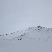 The upper mountain being engulfed by clouds