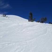 Wind textured snow surfaces in exposed areas, smooth in others.