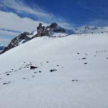 Though snowpack is supports a snowmobile, there are exposed rocks above treeline.